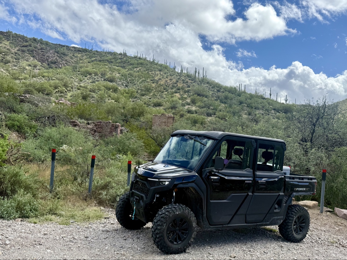 The 6-seat CFMOTO U10 Pro XL Highland parked on a desert trail by old mine ruins, saguaro-covered hills behind it